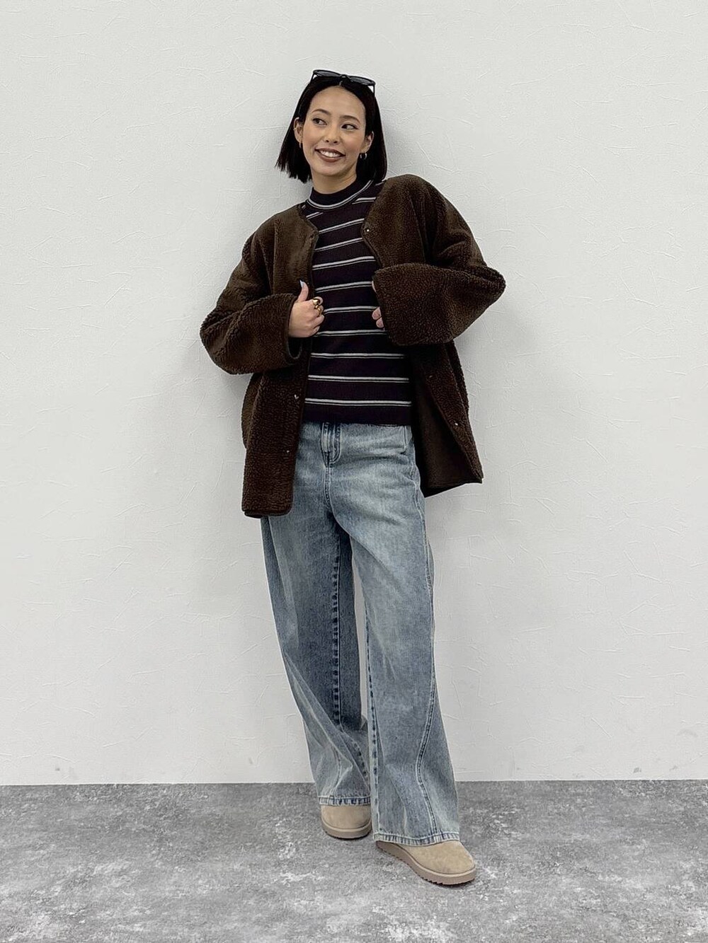 ホワイト系のニット/セーター、ブルー系のデニムパンツ、ブラウン系のノーカラージャケットを着用したレディースの冬コーディネートの7枚目の写真