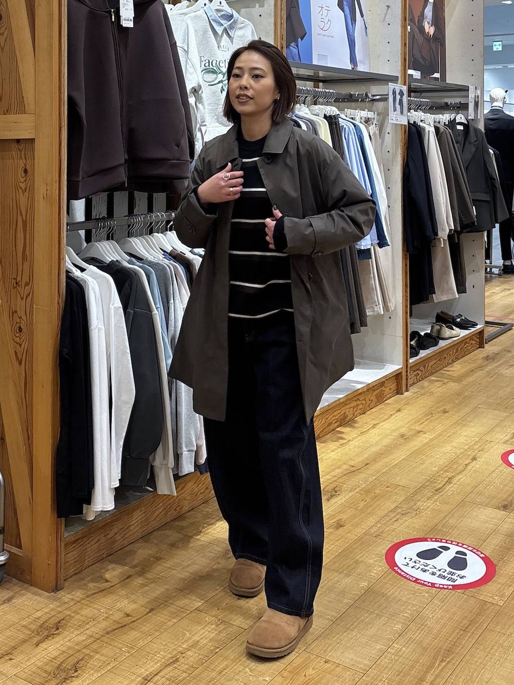 ブラウン系のステンカラーコート、ブルー系のデニムパンツを着用したレディースの冬コーディネートの3枚目の写真