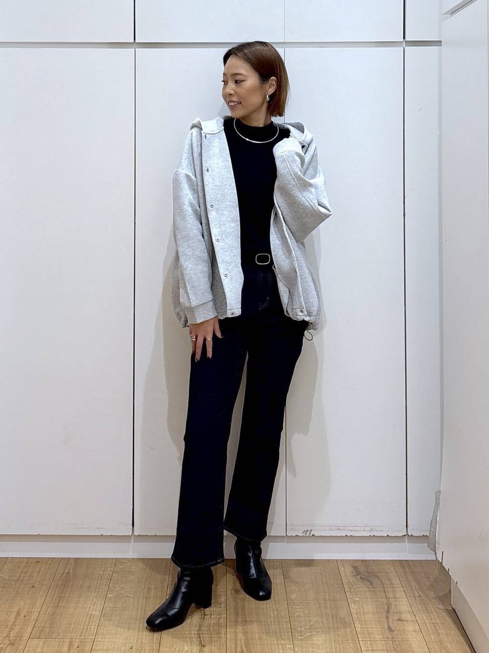 ブルー系のデニムパンツ、ブラック系のニット/セーター、グレー系のブルゾンを着用したレディースの秋コーディネートの7枚目の写真