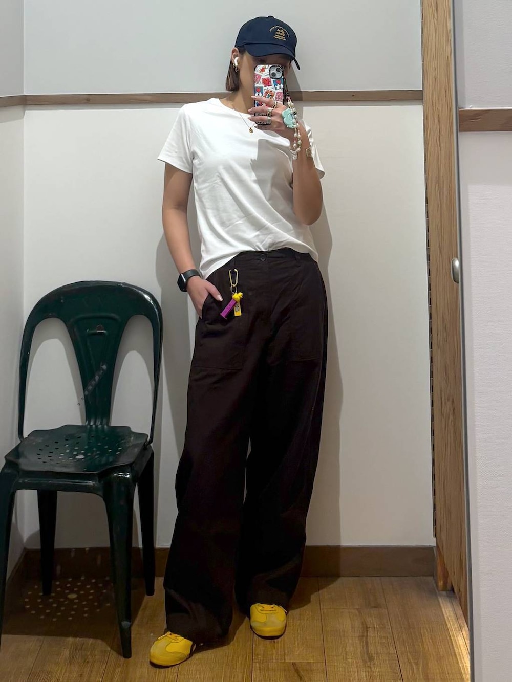 ブラウン系のその他パンツ、ホワイト系のTシャツ/カットソー、その他のキーホルダーを着用したレディースの春コーディネートの2枚目の写真
