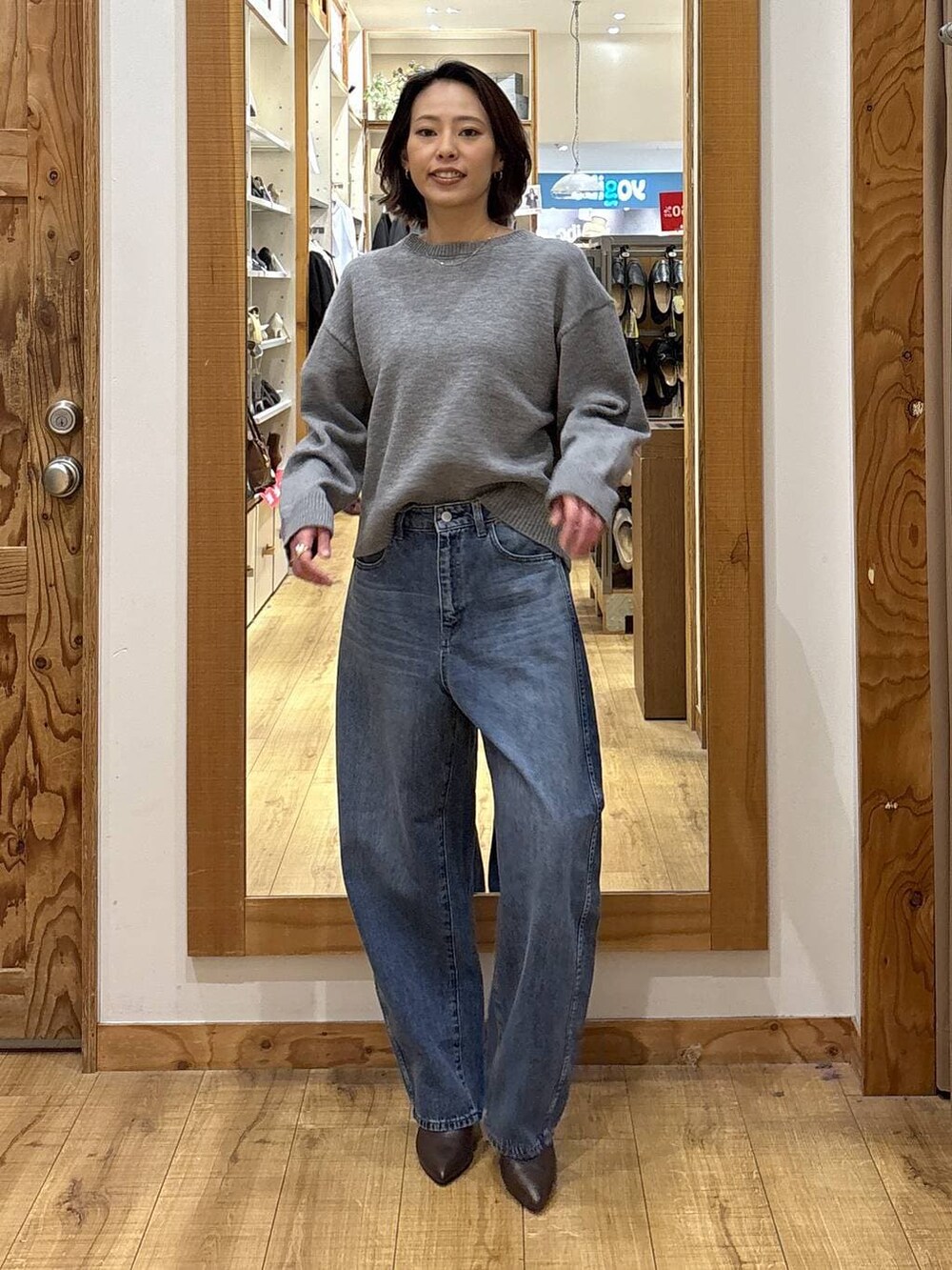 ブルー系のデニムパンツ、ブラウン系のブーツを着用したレディースの冬コーディネートの2枚目の写真