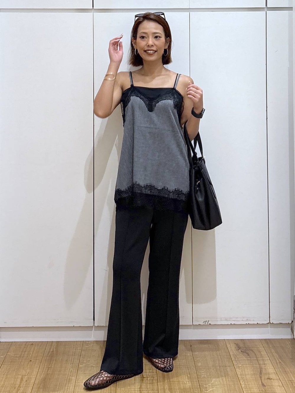 ブラック系のハンドバッグ、ブラック系のキャミソール、ブラック系のサンダルを着用したレディースの夏コーディネートの3枚目の写真