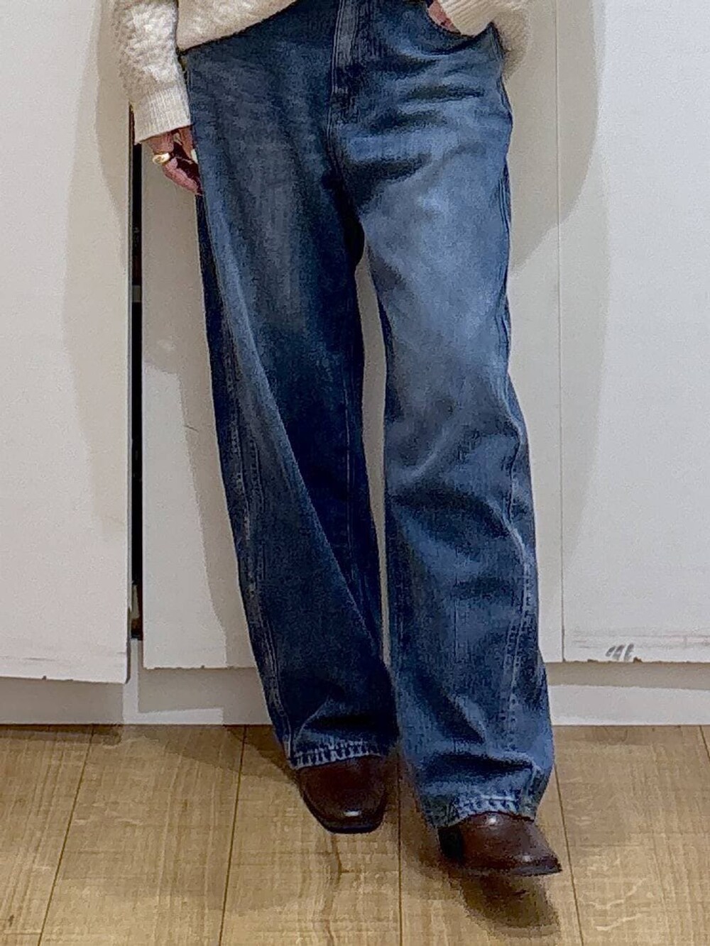 ブラウン系のブーツ、ホワイト系のニット/セーター、ブルー系のデニムパンツを着用したレディースの冬コーディネートの5枚目の写真