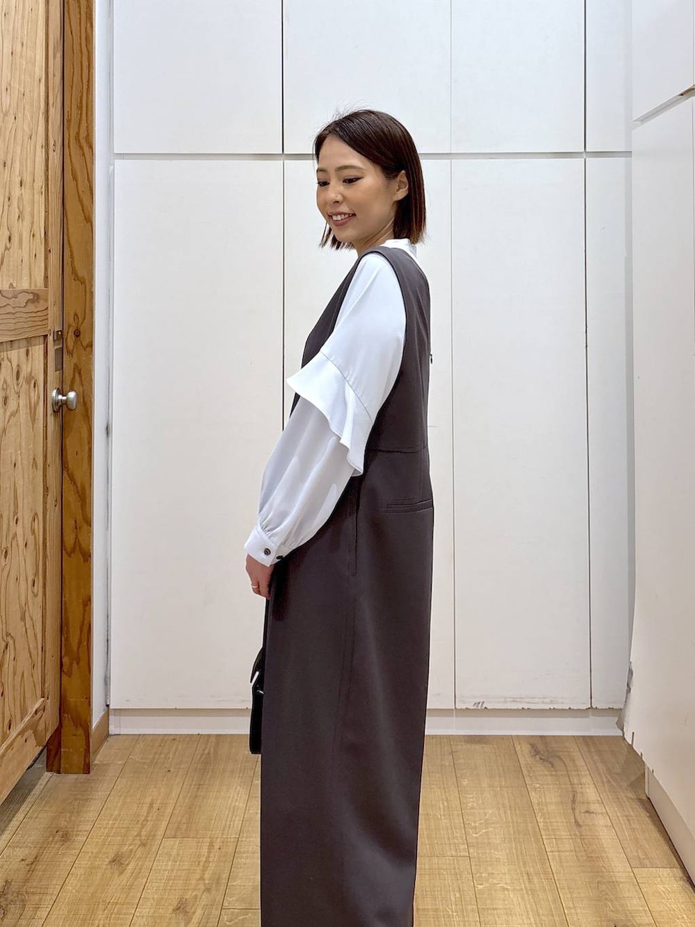 ブラック系のローファー、グレー系のセットアップ、ブラック系のハンドバッグを着用したレディースの冬コーディネートの7枚目の写真