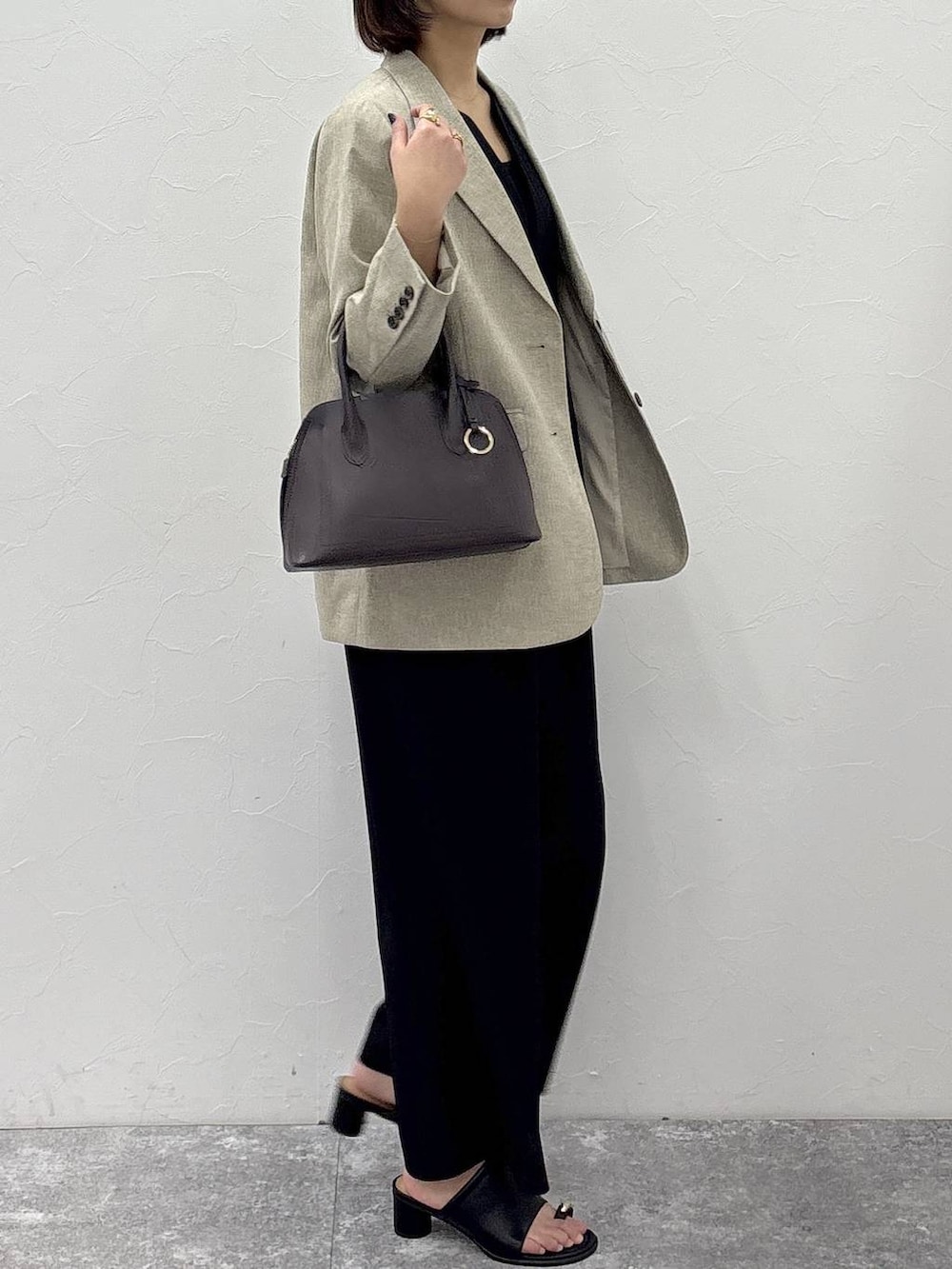 ブラウン系のショルダーバッグ、ベージュ系のテーラードジャケット、ブラック系のサロペット/オーバーオールを着用したレディースの冬コーディネートの3枚目の写真