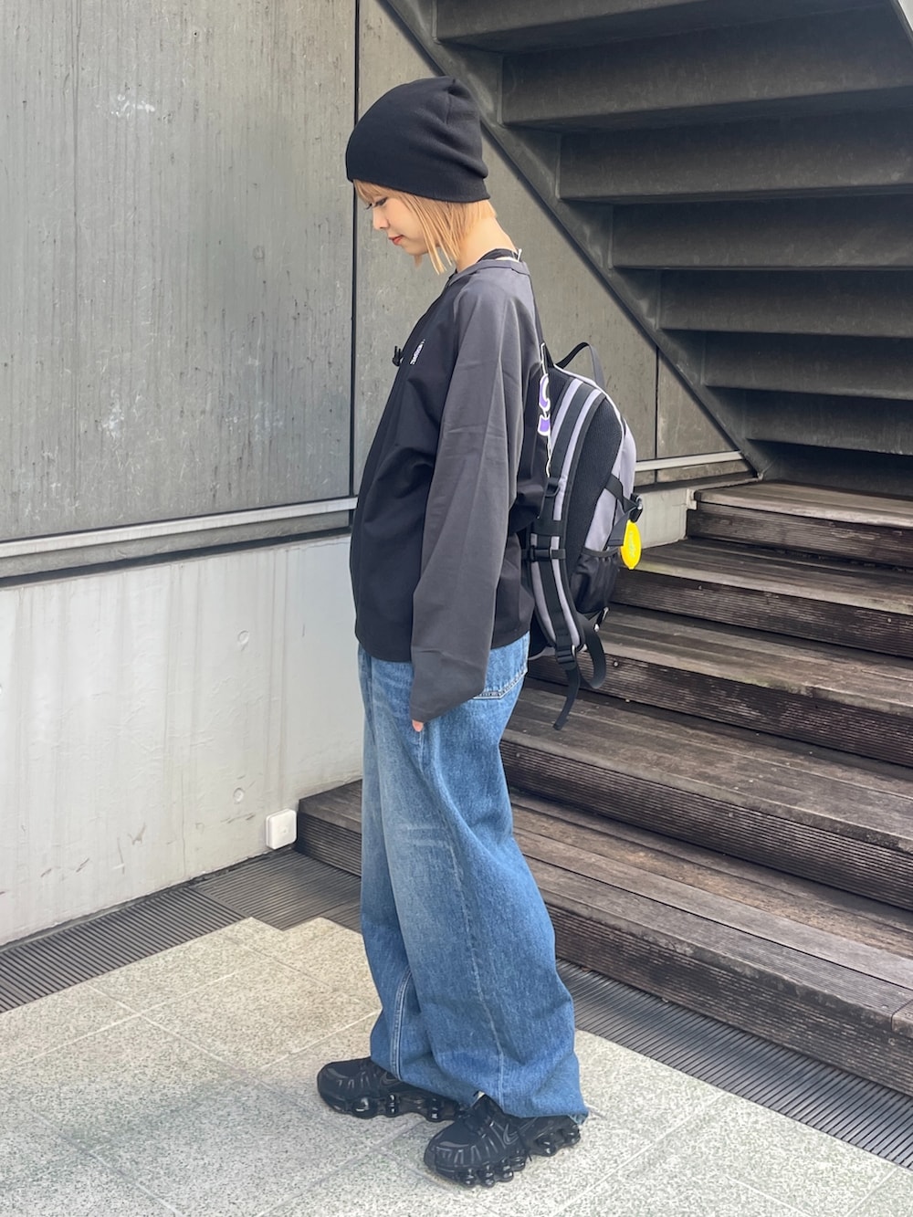 ブラック系のTシャツ/カットソー、ブルー系のデニムパンツ、ブラック系のニットキャップ/ビーニーを着用したレディースの冬コーディネートの2枚目の写真