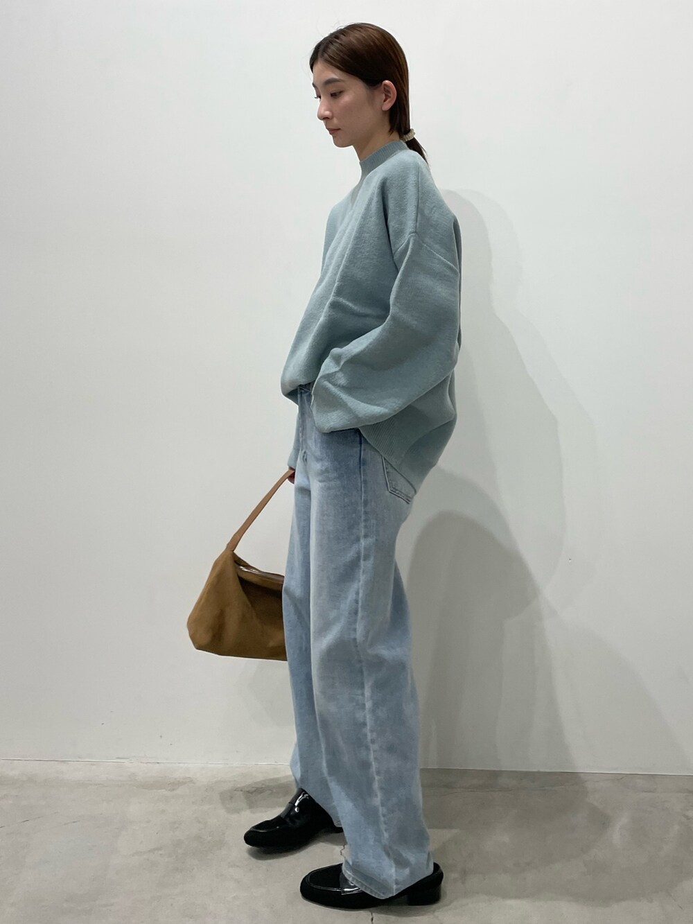 ブルー系のデニムパンツ、ブラック系のローファー、ブラウン系のショルダーバッグを着用したレディースの冬コーディネートの6枚目の写真