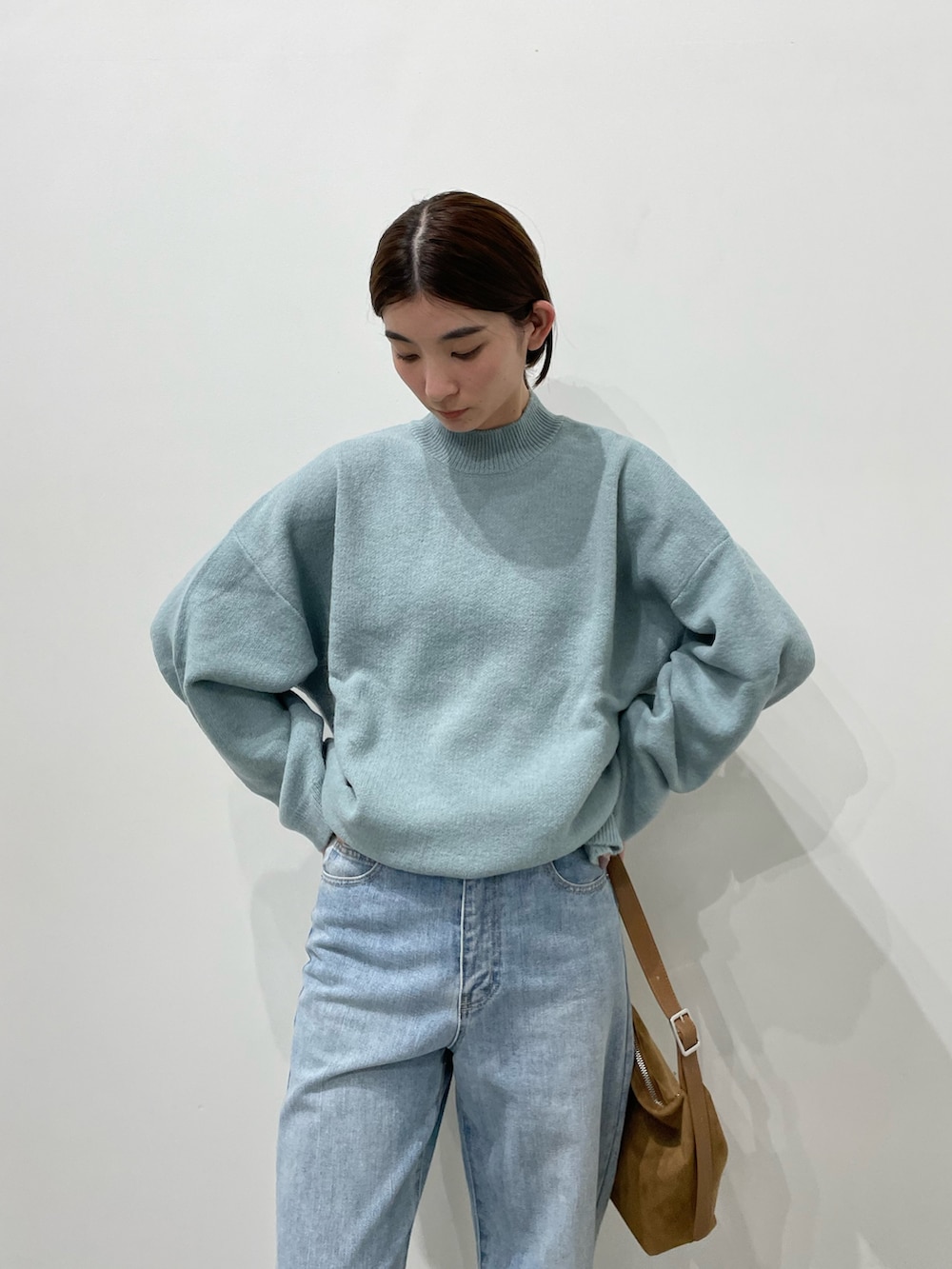 ブルー系のデニムパンツ、ブラック系のローファー、ブラウン系のショルダーバッグを着用したレディースの冬コーディネートの3枚目の写真