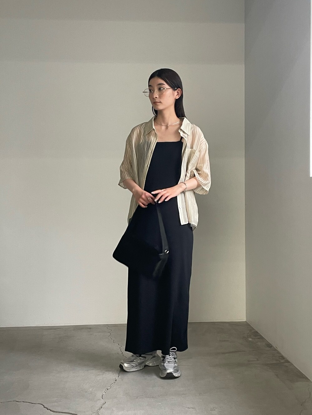 ブラック系のワンピース、ベージュ系のシャツ/ブラウス、シルバー系のブレスレットを着用したレディースの春コーディネートの3枚目の写真