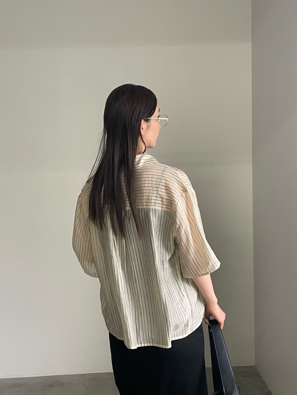 ブラック系のワンピース、ベージュ系のシャツ/ブラウス、シルバー系のブレスレットを着用したレディースの春コーディネートの4枚目の写真