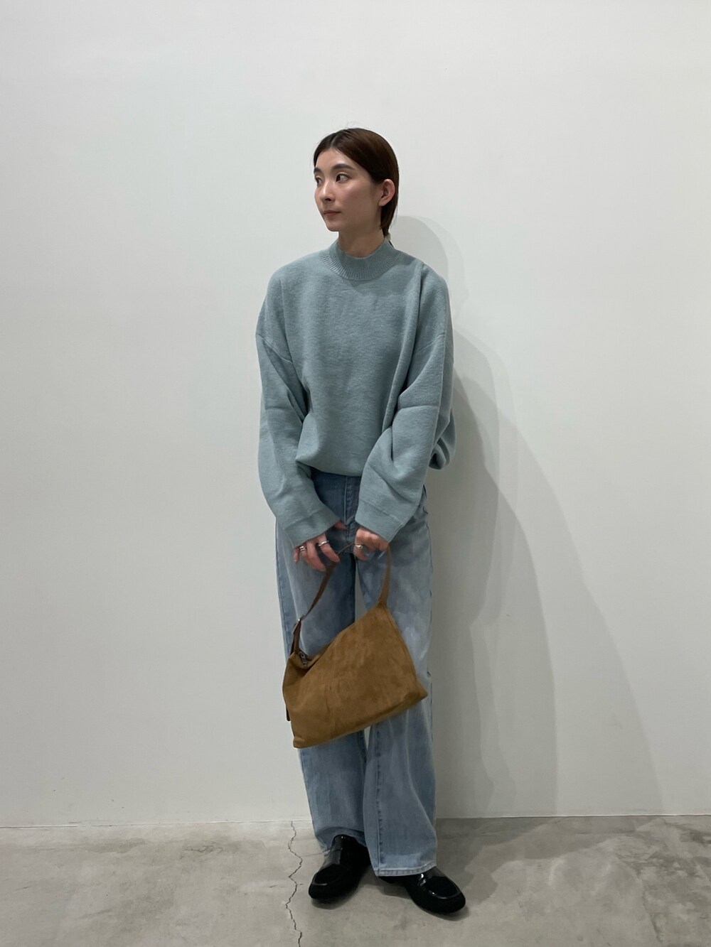 ブルー系のデニムパンツ、ブラック系のローファー、ブラウン系のショルダーバッグを着用したレディースの冬コーディネートの4枚目の写真