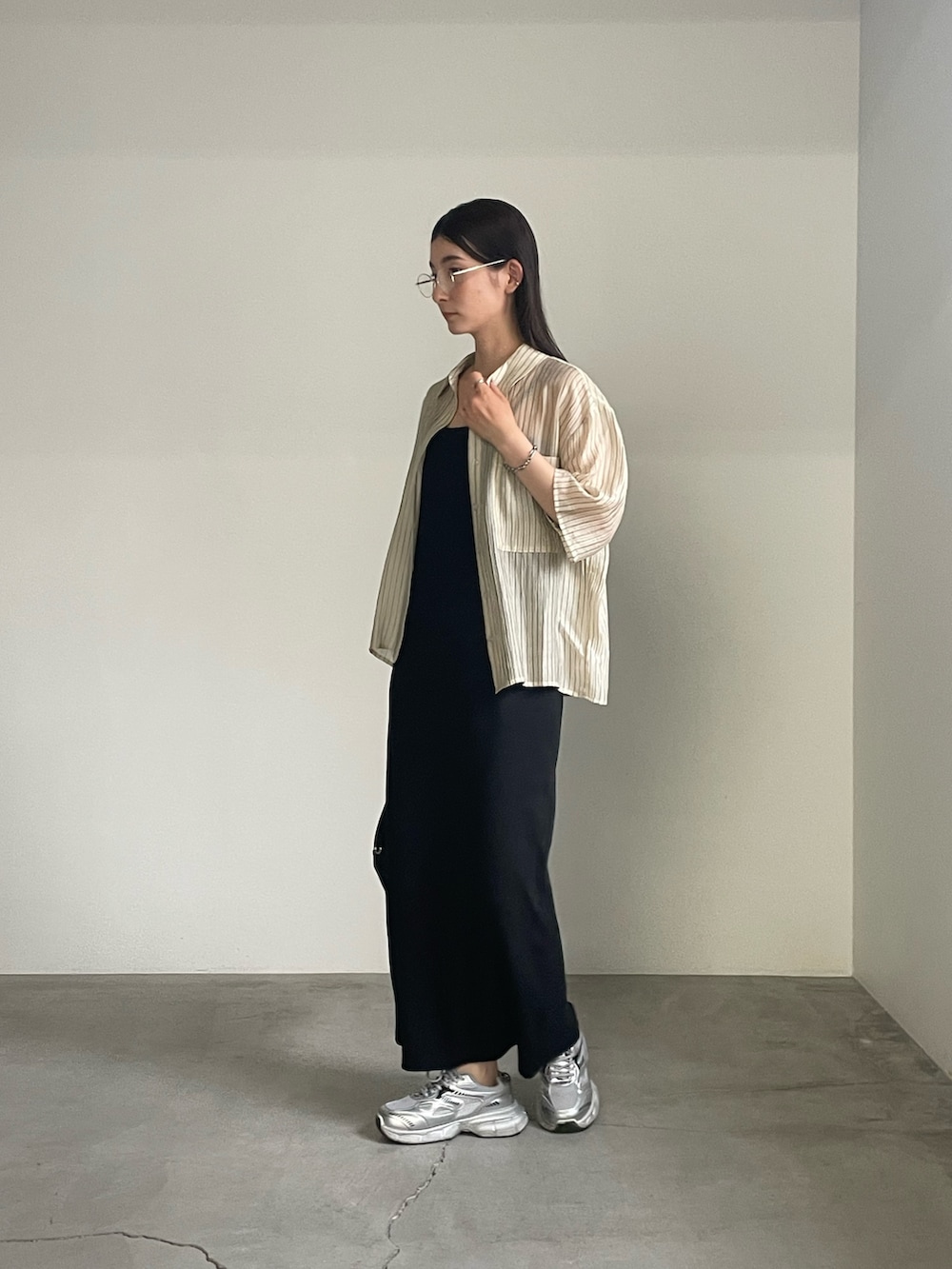 ブラック系のワンピース、ベージュ系のシャツ/ブラウス、シルバー系のブレスレットを着用したレディースの春コーディネートの8枚目の写真