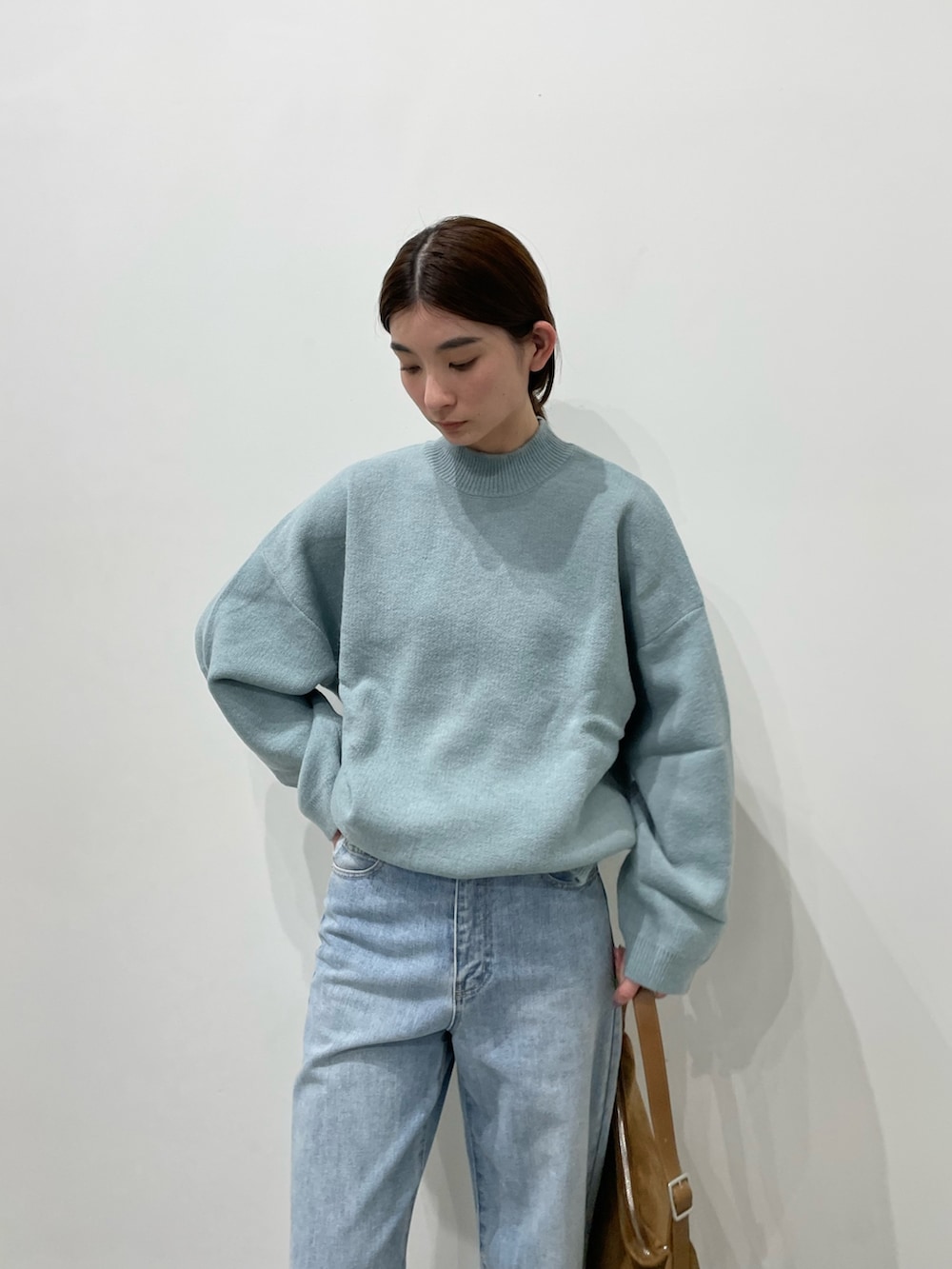 ブルー系のデニムパンツ、ブラック系のローファー、ブラウン系のショルダーバッグを着用したレディースの冬コーディネートの5枚目の写真