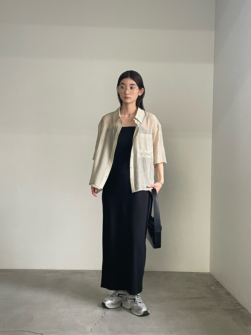 ブラック系のワンピース、ベージュ系のシャツ/ブラウス、シルバー系のブレスレットを着用したレディースの春コーディネートの9枚目の写真
