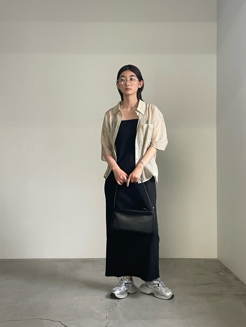 ブラック系のワンピース、ベージュ系のシャツ/ブラウス、シルバー系のブレスレットを着用したレディースの春コーディネートの5枚目の写真