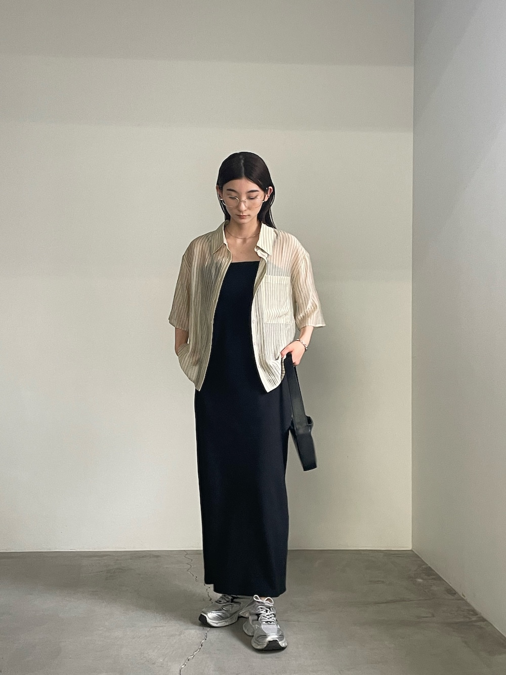 ブラック系のワンピース、ベージュ系のシャツ/ブラウス、シルバー系のブレスレットを着用したレディースの春コーディネートの2枚目の写真