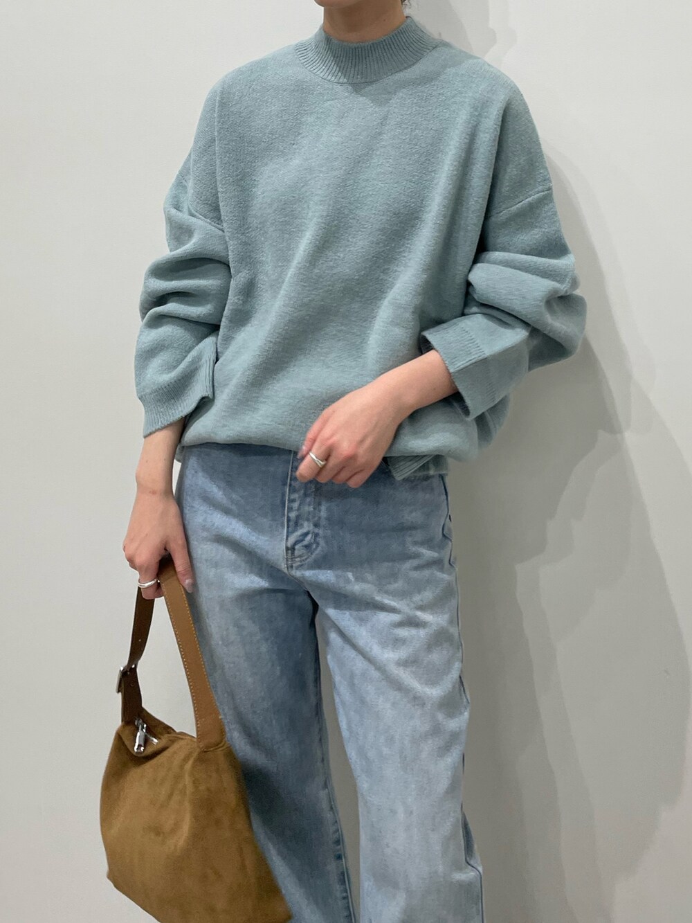 ブルー系のデニムパンツ、ブラック系のローファー、ブラウン系のショルダーバッグを着用したレディースの冬コーディネートの7枚目の写真