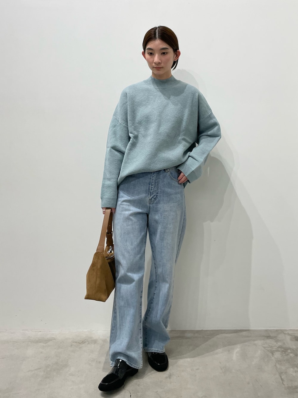 ブルー系のデニムパンツ、ブラック系のローファー、ブラウン系のショルダーバッグを着用したレディースの冬コーディネートの2枚目の写真