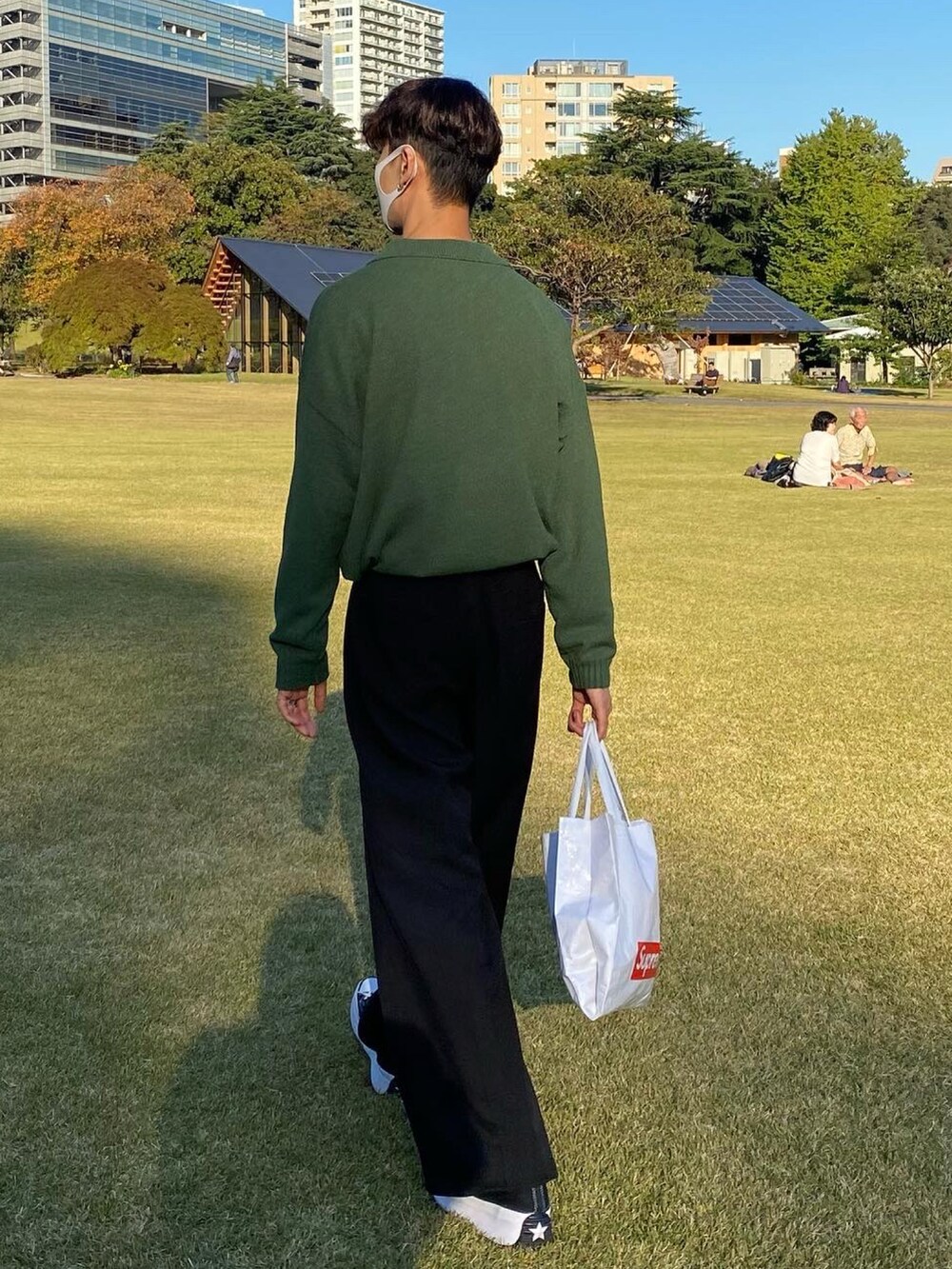 ブラック系のスニーカー、ブラック系のパンツ、ホワイト系のバッグを着用したメンズの冬コーディネートの2枚目の写真