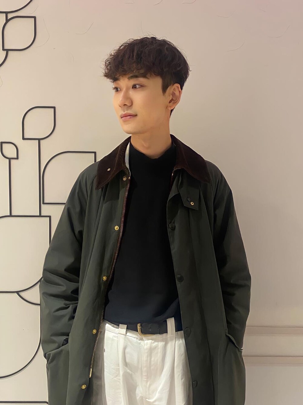 グリーン系のジャケット/アウター、ホワイト系のショルダーバッグ、ブラック系のニット/セーターを着用したメンズの冬コーディネートの3枚目の写真