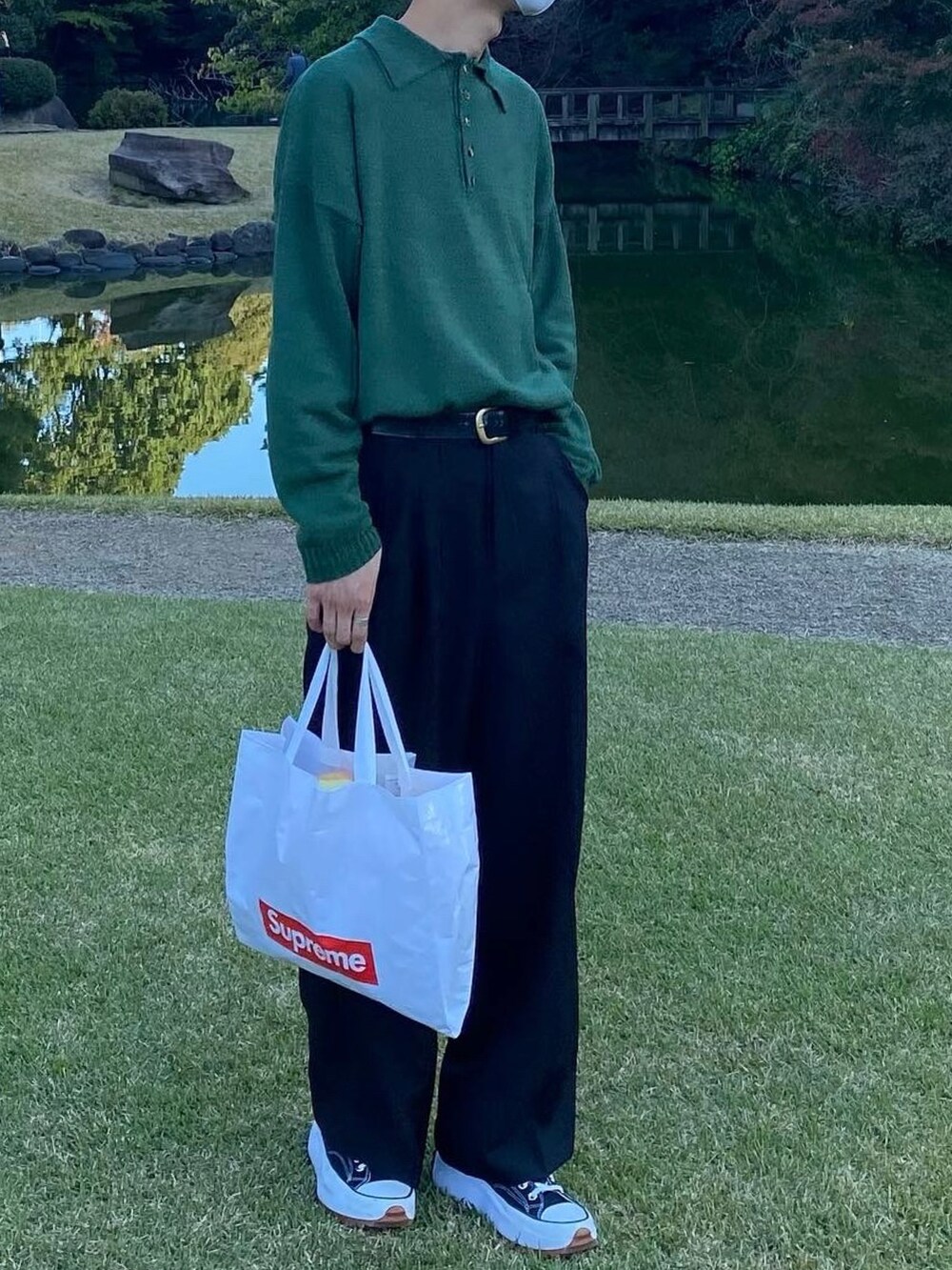 ブラック系のスニーカー、ブラック系のパンツ、ホワイト系のバッグを着用したメンズの冬コーディネートの4枚目の写真