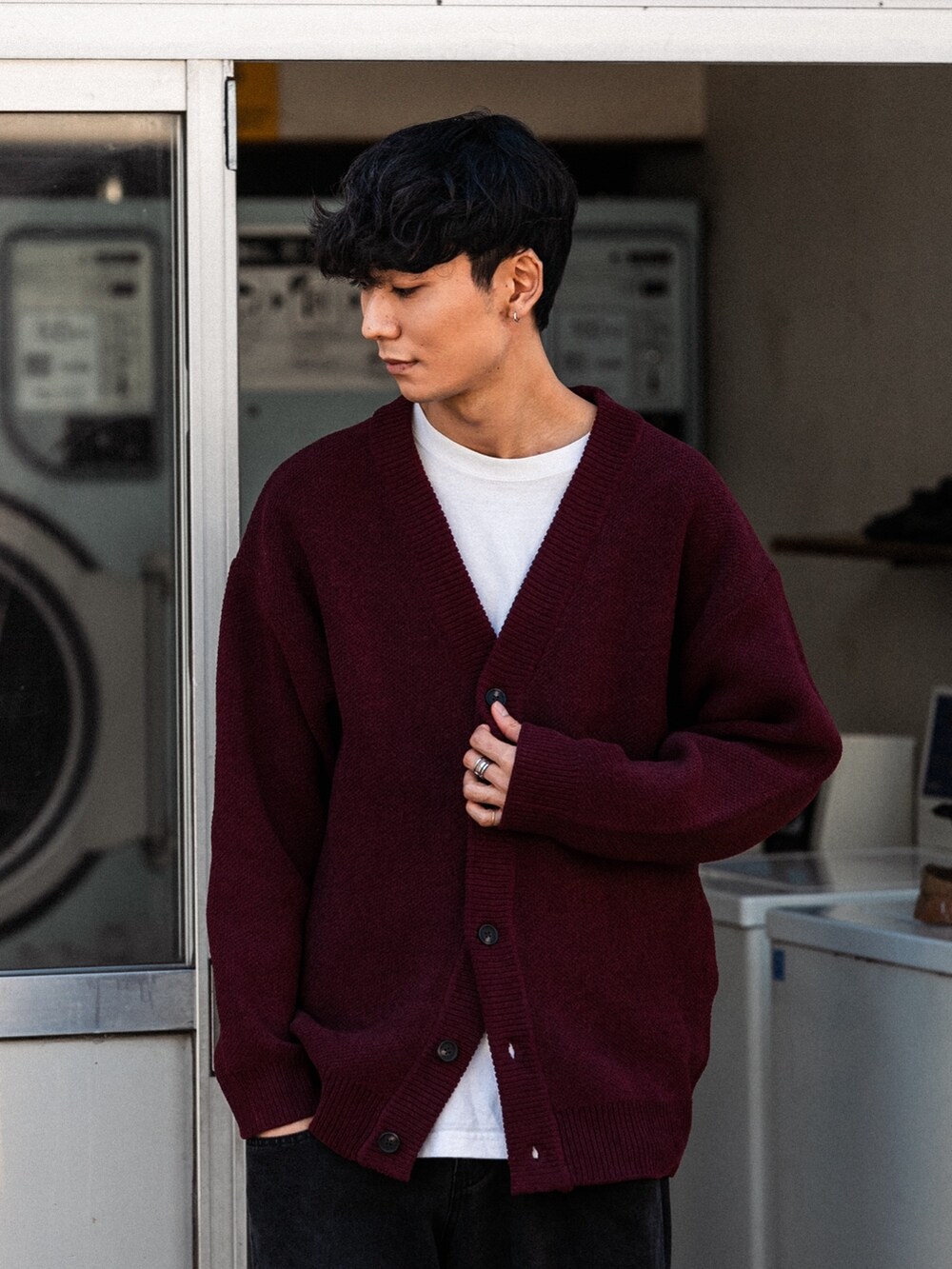 レッド系のカーディガン/ボレロ、ブラック系のデニムパンツ、ブラック系のスニーカーを着用したメンズの秋コーディネートの4枚目の写真