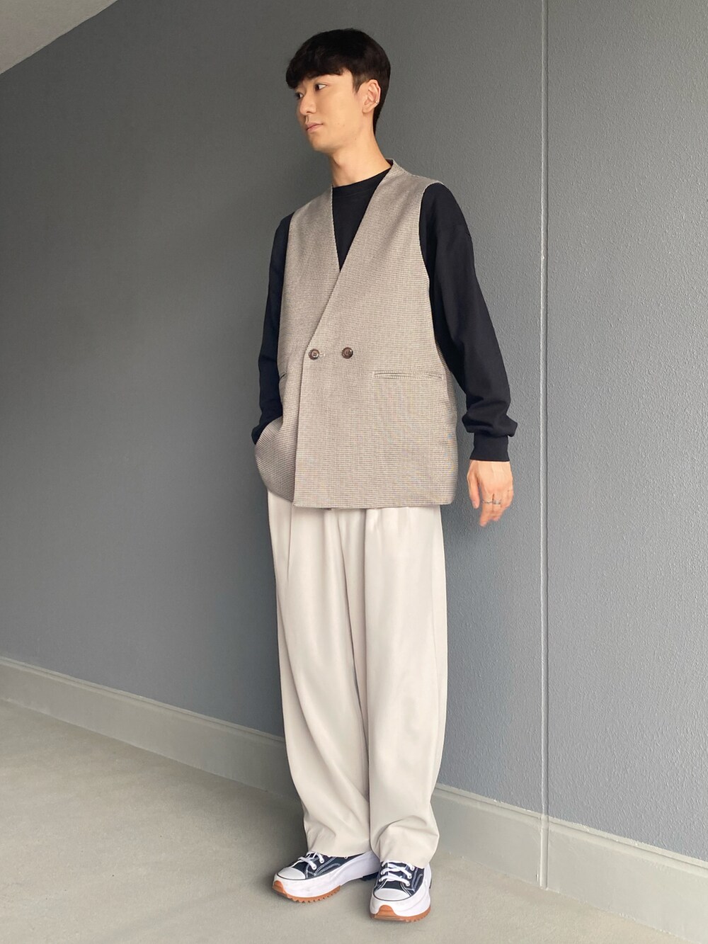 ブラック系のシューズ、ベージュ系のスラックス、ブラック系のTシャツ/カットソーを着用したメンズの春コーディネートの2枚目の写真