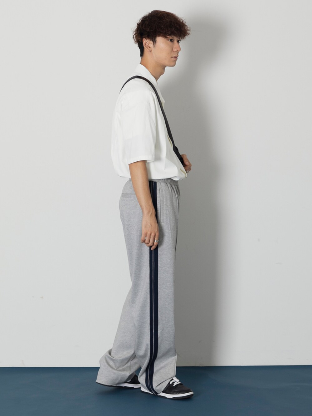 ホワイト系のシャツ/ブラウス、ブラック系のショルダーバッグ、ブラック系のスニーカーを着用したメンズの秋コーディネートの2枚目の写真