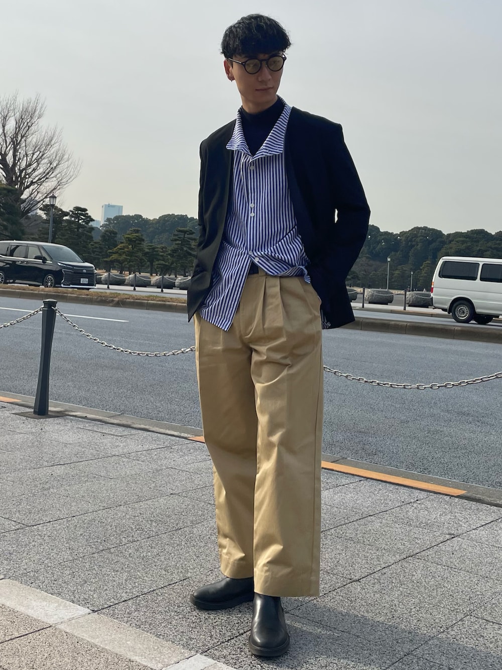 ブラック系のブーツ、ブルー系のシャツ/ブラウス、ブラック系のノーカラーコートを着用したメンズの冬コーディネートの2枚目の写真