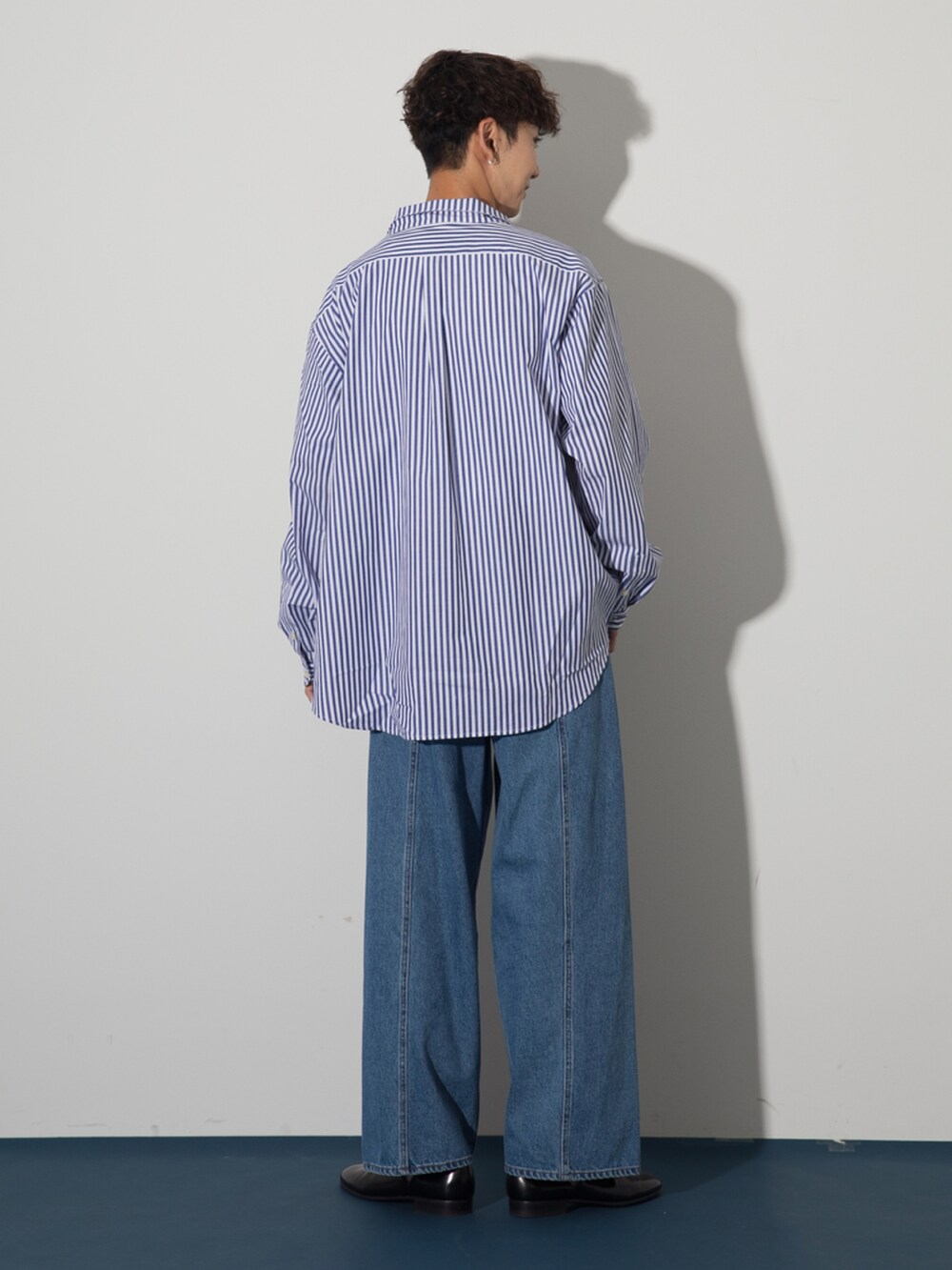 ブラック系のその他シューズ、ブルー系のデニムパンツ、ブルー系のシャツ/ブラウスを着用したメンズの夏コーディネートの3枚目の写真