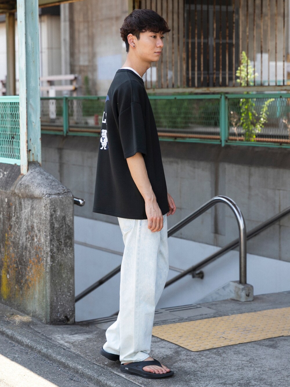 ブラック系のサンダル、ブルー系のデニムパンツ、ブラック系のTシャツ/カットソーを着用したメンズの夏コーディネートの4枚目の写真