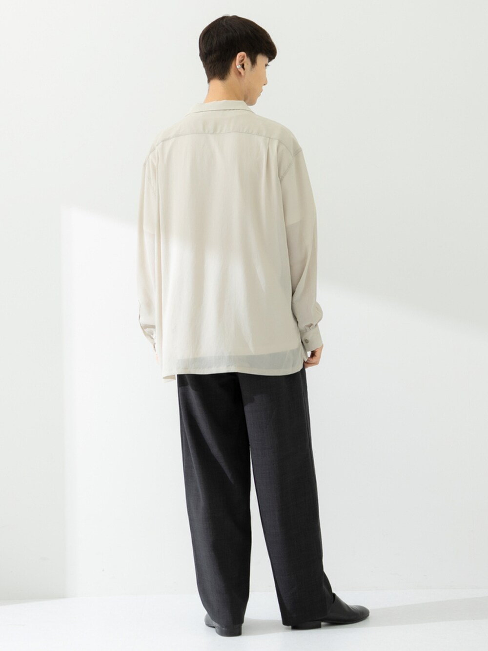 ブラック系のその他シューズ、グレー系のスラックス、ベージュ系のシャツ/ブラウスを着用したメンズの春コーディネートの3枚目の写真