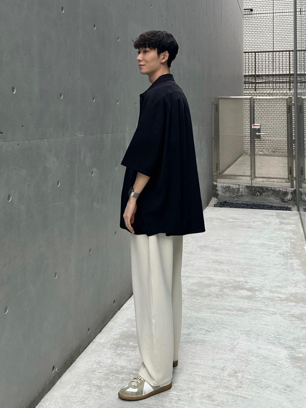 ブラック系のシャツ/ブラウス、ホワイト系のパンツ、ホワイト系のスニーカーを着用したメンズの春コーディネートの2枚目の写真