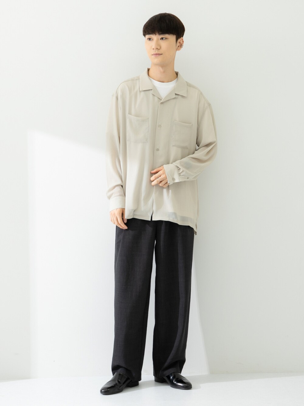 ブラック系のその他シューズ、グレー系のスラックス、ベージュ系のシャツ/ブラウスを着用したメンズの春コーディネートの2枚目の写真