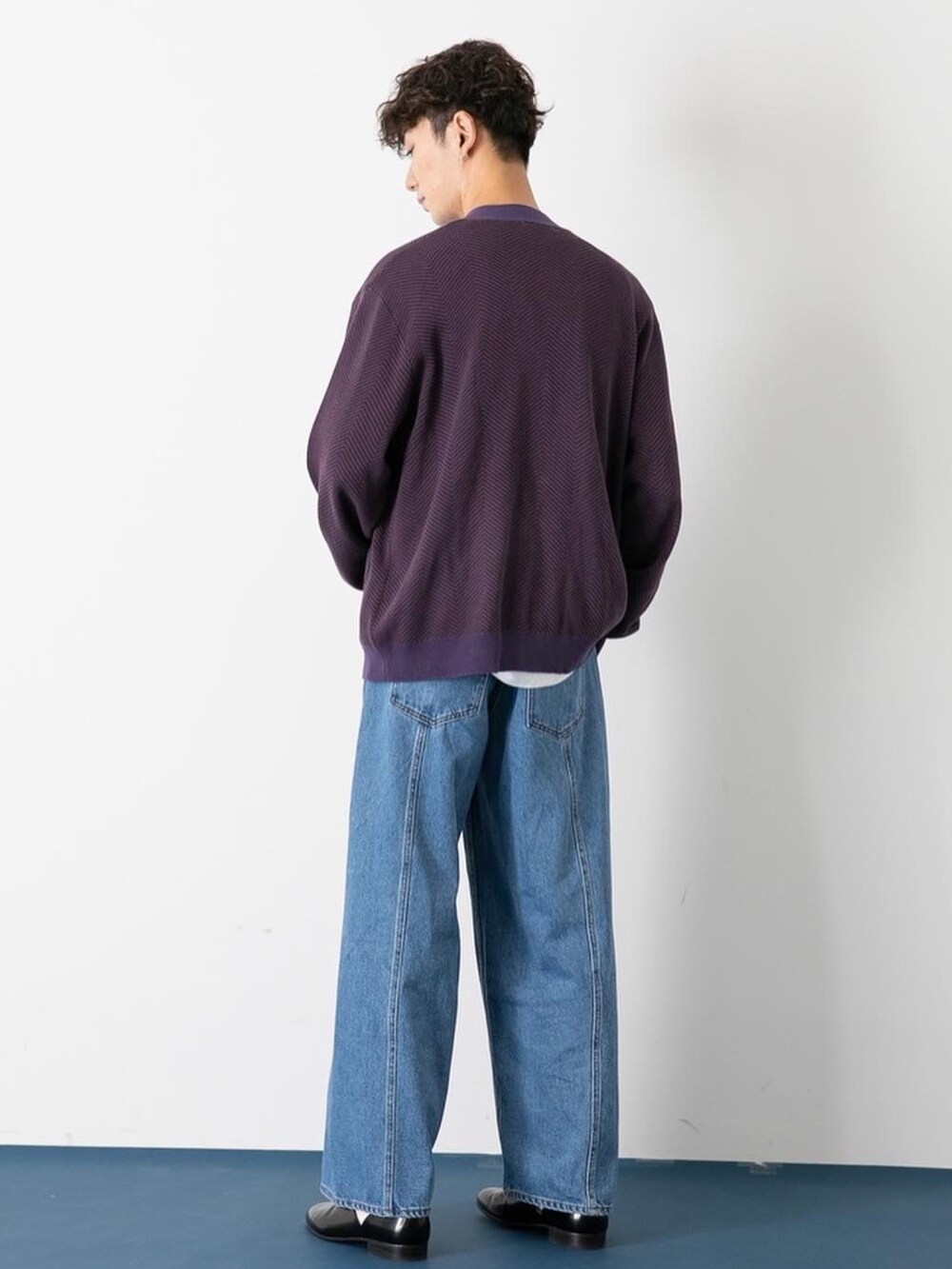 ブラック系のドレスシューズ、ブルー系のデニムパンツ、パープル系のカーディガン/ボレロを着用したメンズの秋コーディネートの3枚目の写真