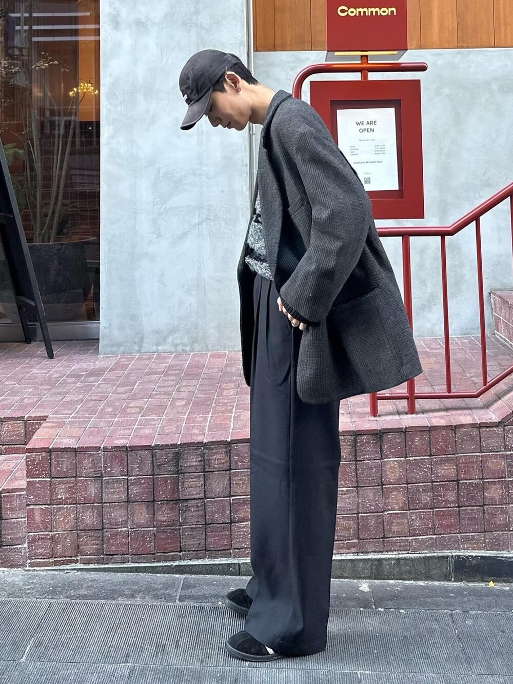 ブラック系のスニーカー、ブラック系のスラックス、ブラック系のニット/セーターを着用したメンズの冬コーディネートの3枚目の写真