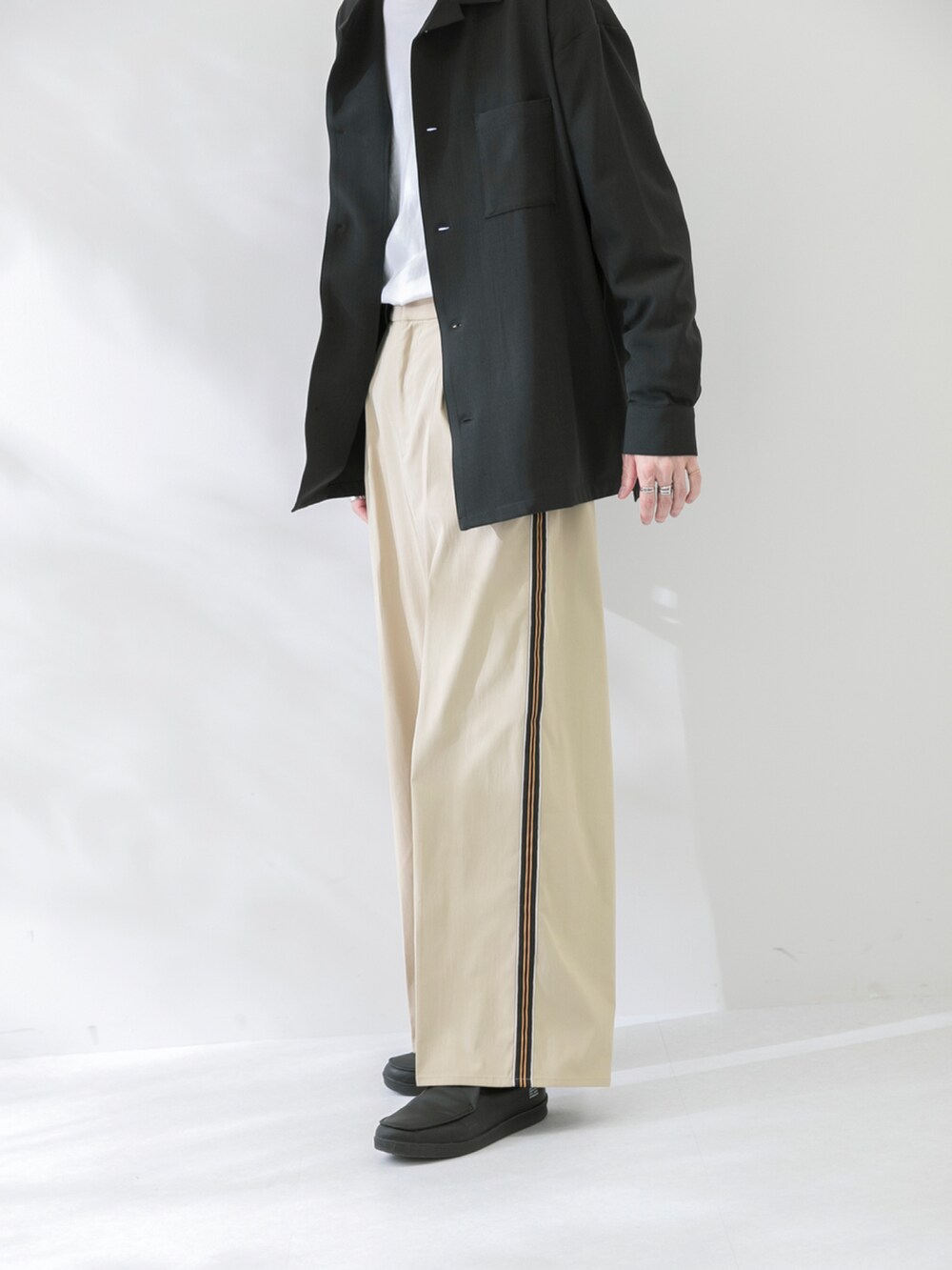 ブラック系のシューズ、ベージュ系のパンツ、ブラック系のシャツ/ブラウスを着用したメンズの春コーディネートの3枚目の写真