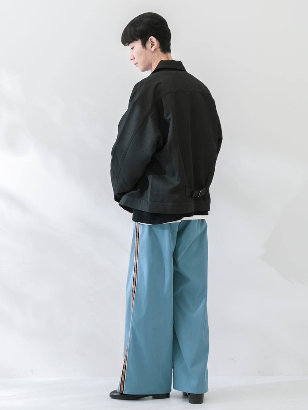 ブラック系のその他シューズ、ベージュ系のパンツ、ホワイト系のTシャツ/カットソーを着用したメンズの春コーディネートの2枚目の写真