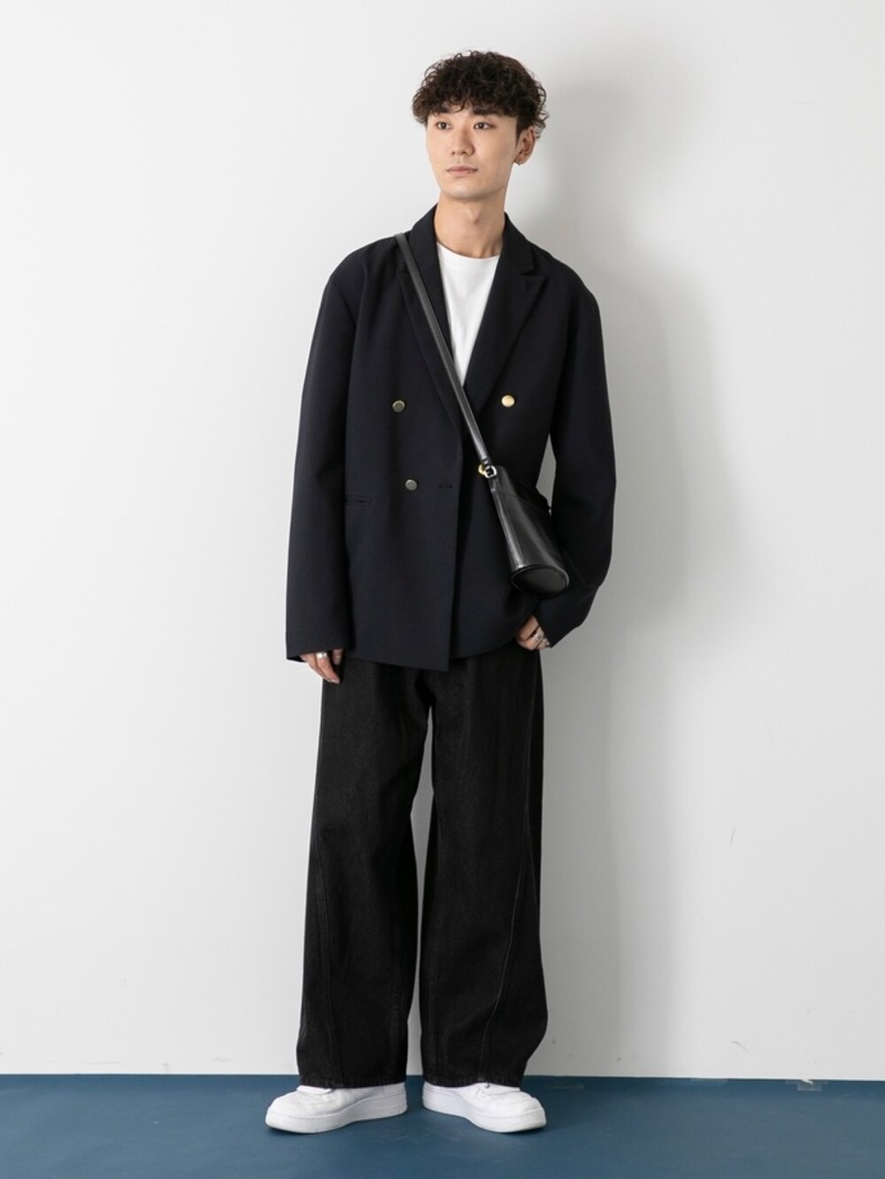 ホワイト系のシューズ、ブラック系のデニムパンツ、ブルー系のテーラードジャケットを着用したメンズの秋コーディネートの2枚目の写真