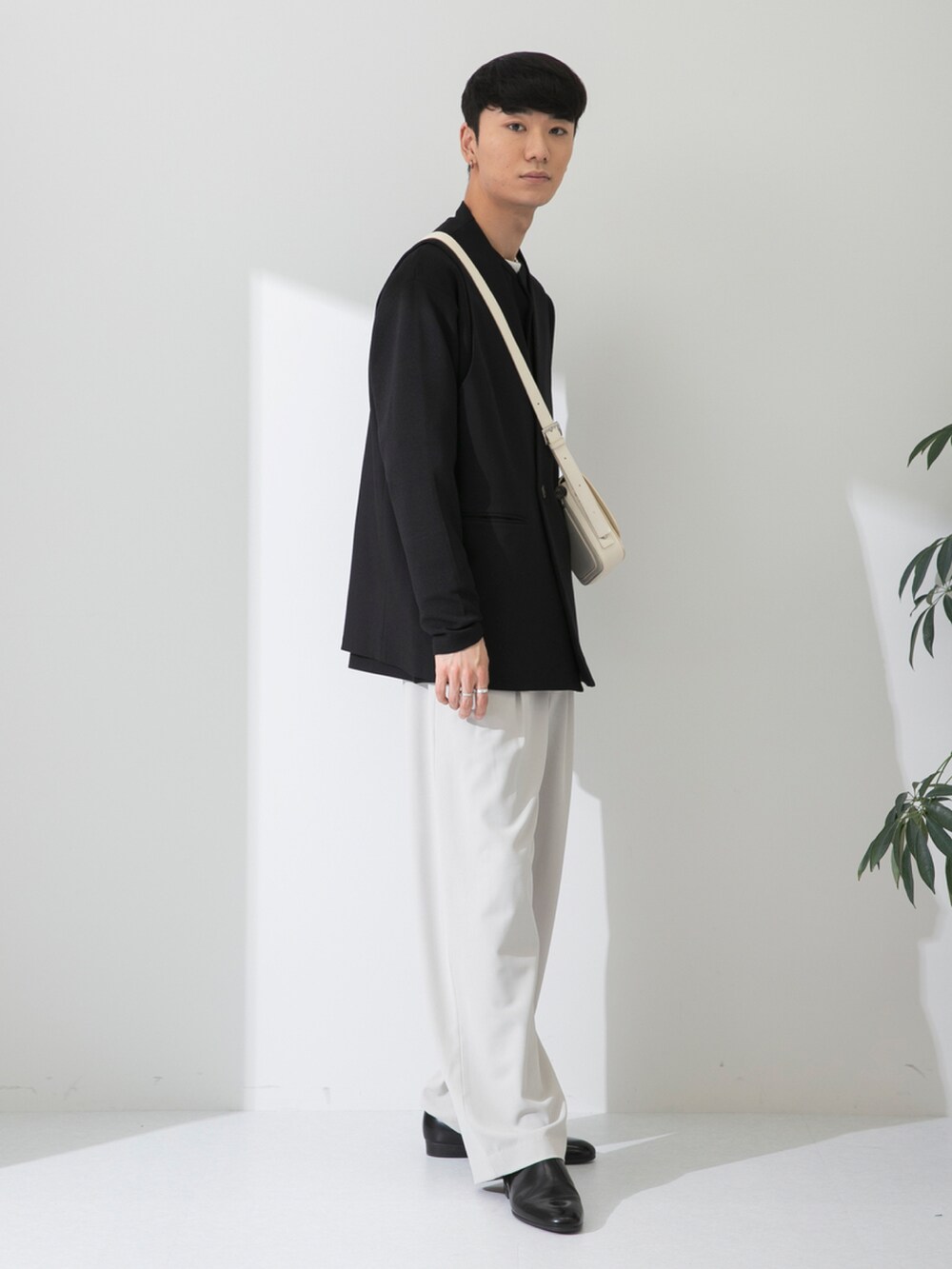 ブラック系のその他シューズ、ベージュ系のスラックス、ホワイト系のショルダーバッグを着用したメンズの春コーディネートの3枚目の写真