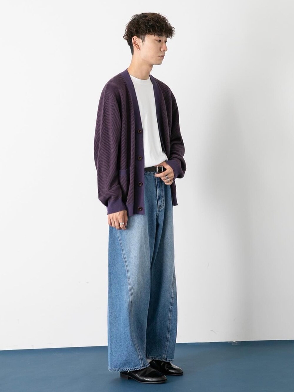 ブラック系のドレスシューズ、ブルー系のデニムパンツ、パープル系のカーディガン/ボレロを着用したメンズの秋コーディネートの2枚目の写真