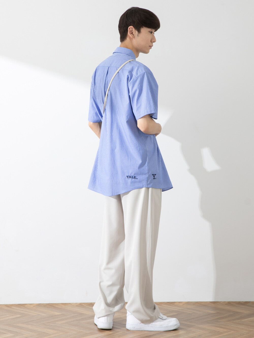 ホワイト系のスニーカー、ホワイト系のその他パンツ、ブルー系のシャツ/ブラウスを着用したメンズの春コーディネートの2枚目の写真