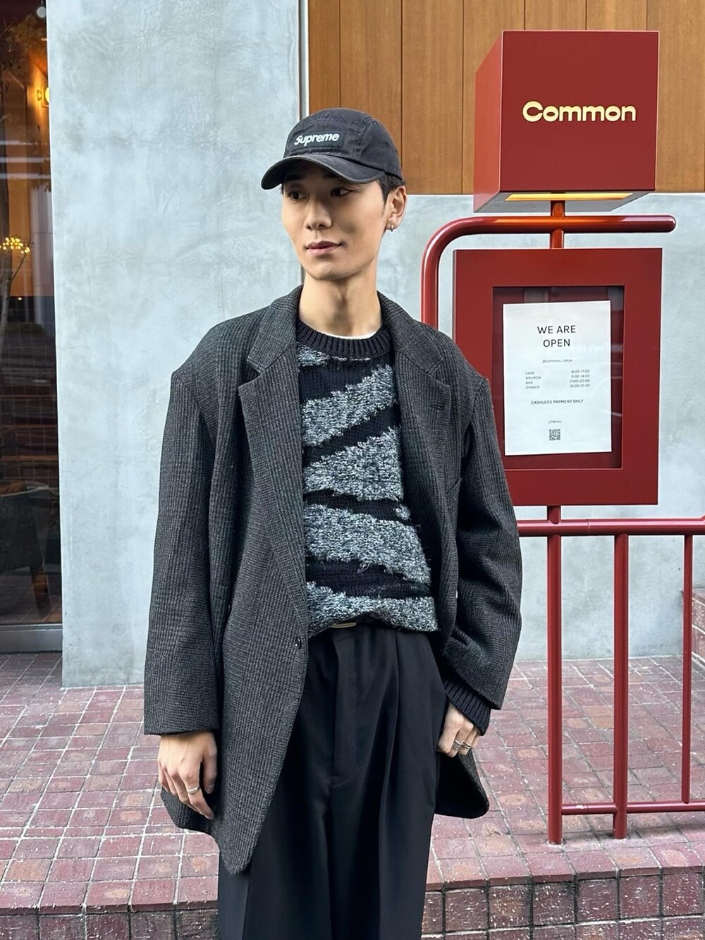 ブラック系のスニーカー、ブラック系のスラックス、ブラック系のニット/セーターを着用したメンズの冬コーディネートの5枚目の写真