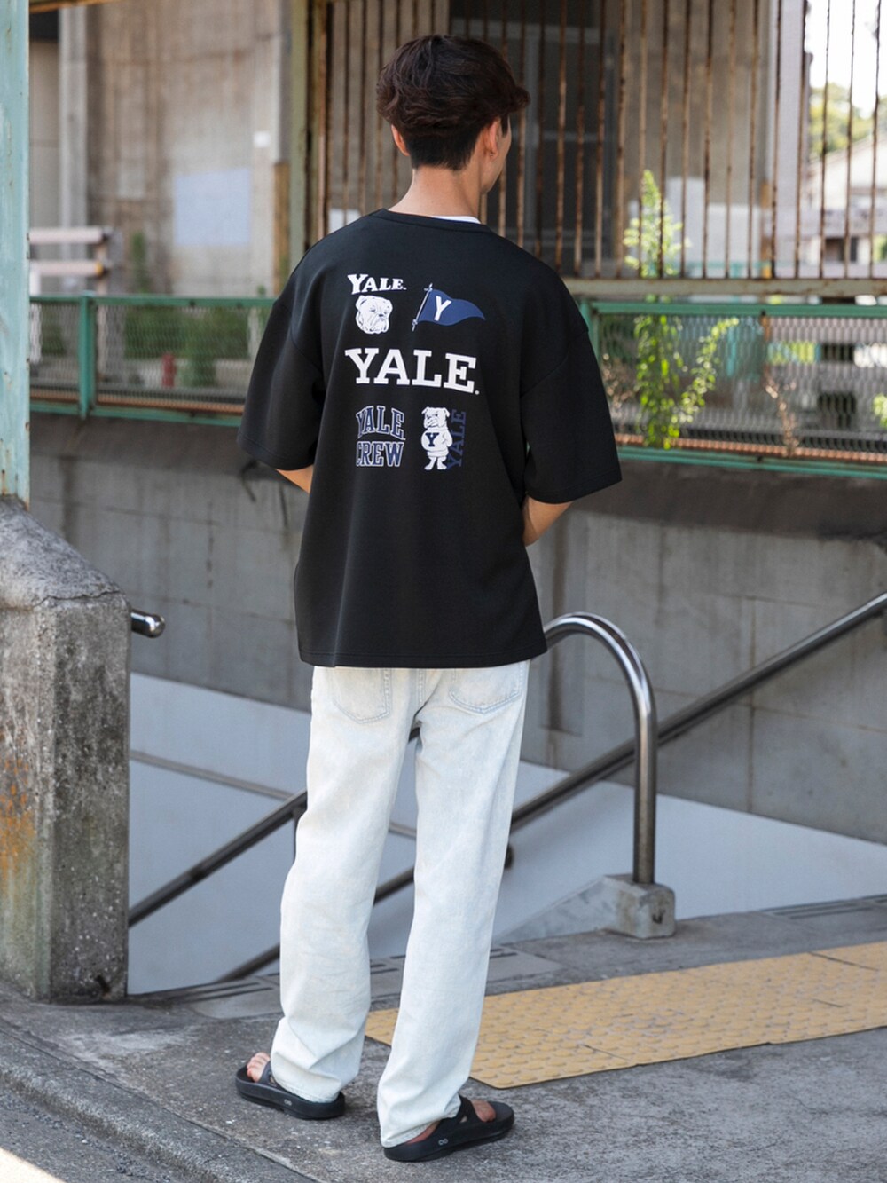 ブラック系のサンダル、ブルー系のデニムパンツ、ブラック系のTシャツ/カットソーを着用したメンズの夏コーディネートの3枚目の写真