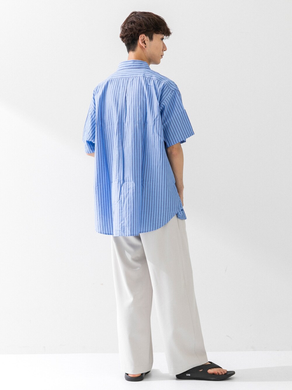 ブラック系のサンダル、ホワイト系のその他パンツ、ブルー系のシャツ/ブラウスを着用したメンズの夏コーディネートの2枚目の写真