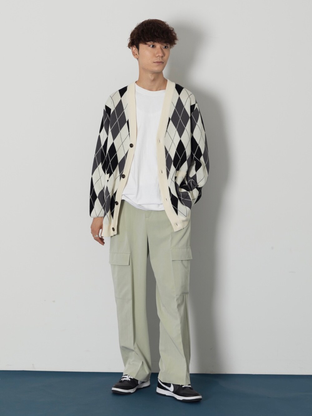 ブラック系のスニーカー、ベージュ系のパンツ、ホワイト系のTシャツ/カットソーを着用したメンズの秋コーディネートの2枚目の写真