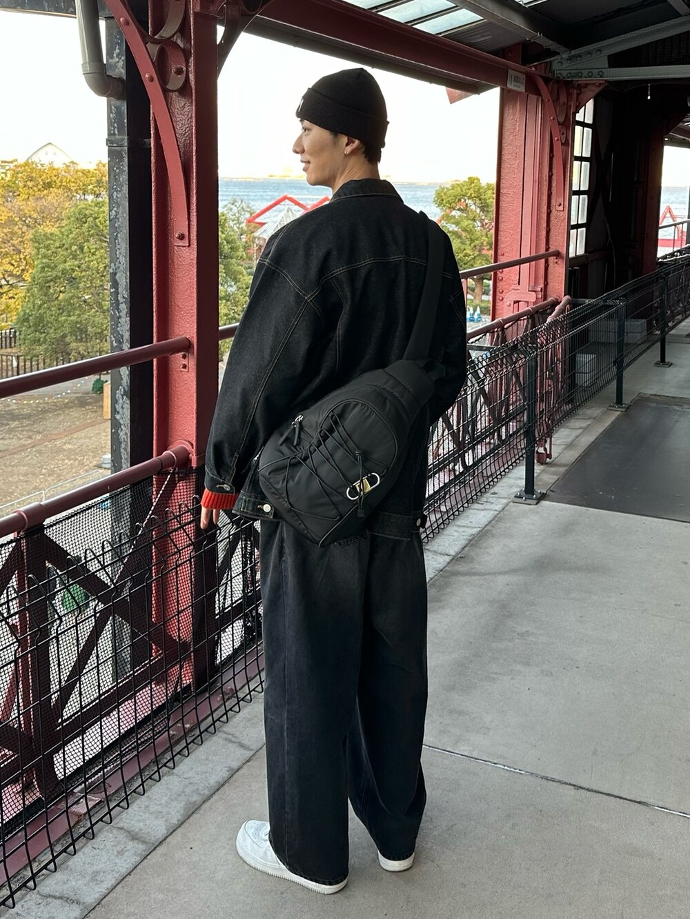 ホワイト系のスニーカー、ブラック系のデニムパンツ、ブラック系のデニムジャケットを着用したメンズの冬コーディネートの3枚目の写真