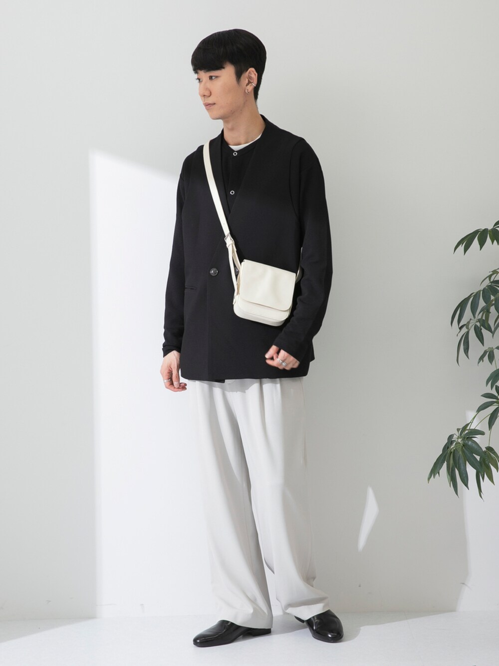 ブラック系のその他シューズ、ベージュ系のスラックス、ホワイト系のショルダーバッグを着用したメンズの春コーディネートの2枚目の写真
