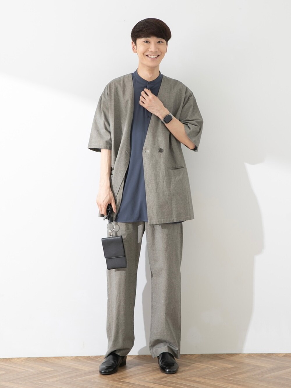 ブラック系のその他シューズ、ベージュ系のその他アウター、ベージュ系のスラックスを着用したメンズの春コーディネートの2枚目の写真