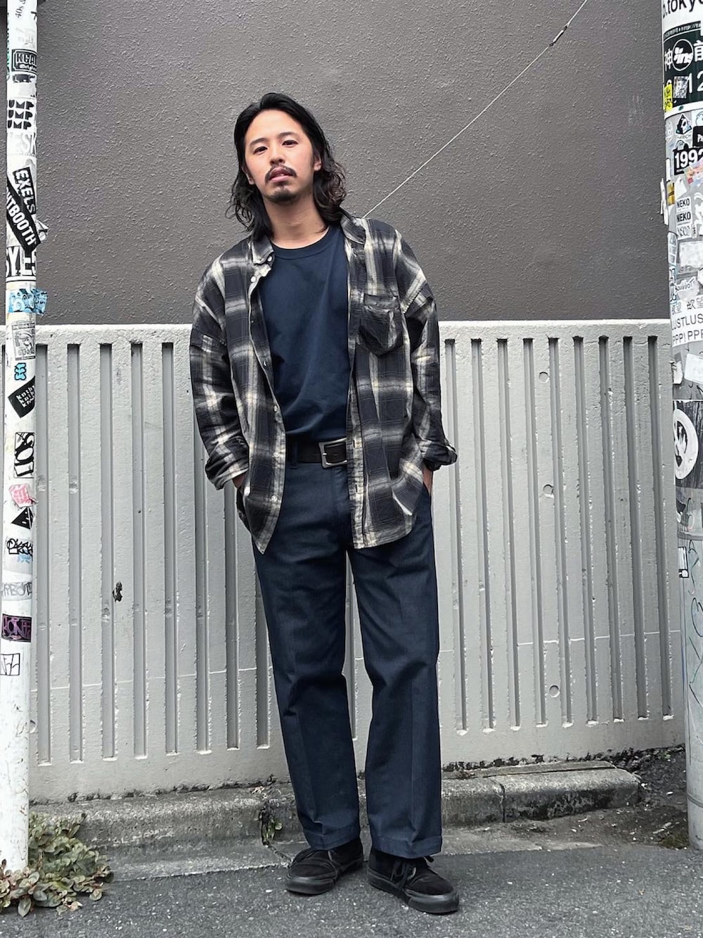 ブルー系のデニムパンツ、ブラック系のスニーカー、ブルー系のTシャツ/カットソーを着用したメンズの秋コーディネートの2枚目の写真